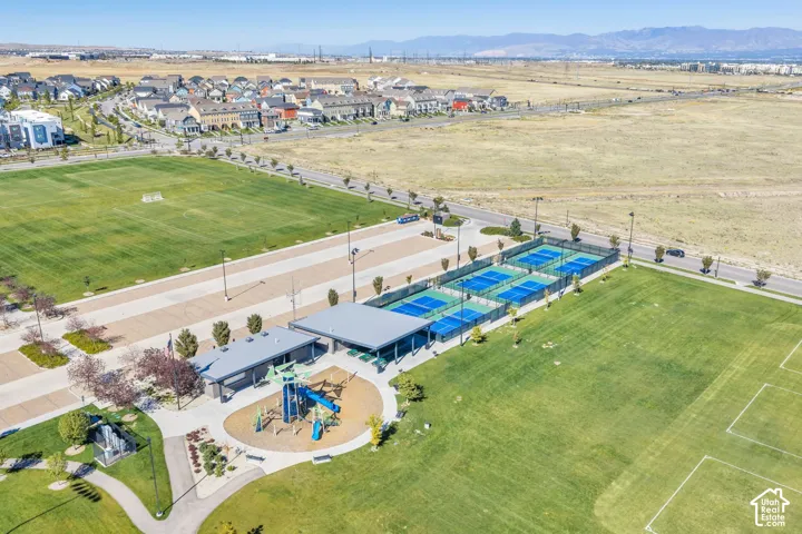 Expansive green spaces featuring multiple sports fields, pickleball courts, and a playground with shade structures