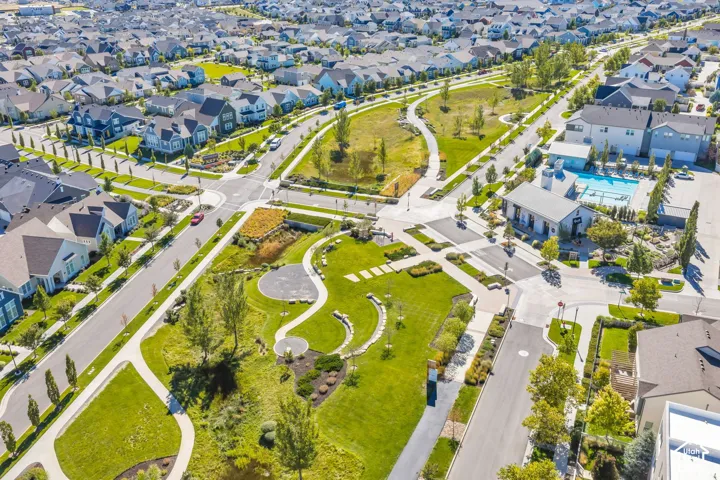 Expansive community featuring multiple green spaces, paved walking paths, a community pool, and a clubhouse