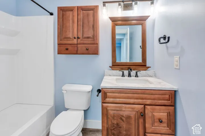 Single basin vanity with a white countertop and dark wood-finish cabinetry