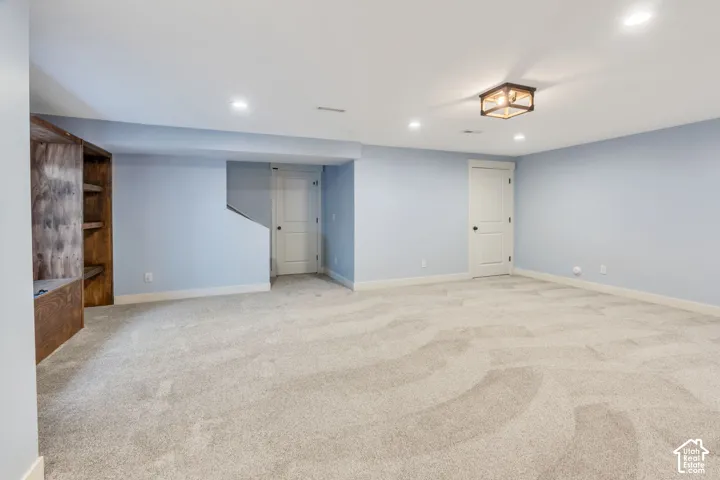 Expansive room featuring light blue walls, recessed lighting, and a drum-style ceiling light
