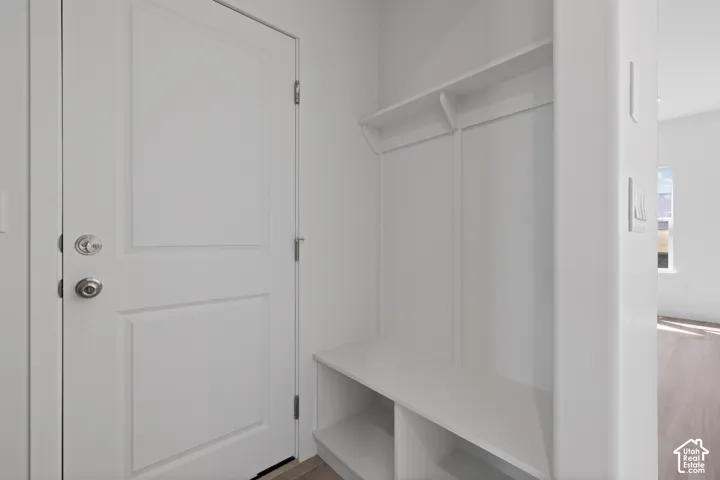 Built-in bench with storage cubbies and shelving, featuring a panel-style door with brushed nickel hardware