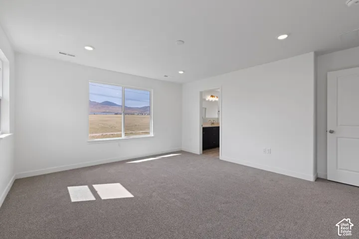 Spacious room with gray carpet flooring and recessed lighting