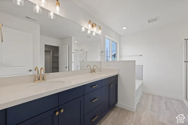 Dual vanity with white countertop, navy cabinetry, and gold-finish fixtures