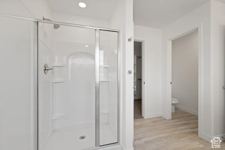 Enclosed shower with sliding glass doors and integrated shelving