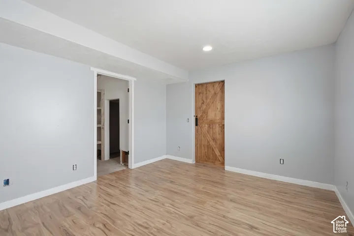 Wood-finish flooring, recessed lighting, and a wood barn-style door