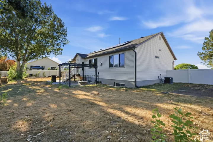 Siding exterior with multiple windows, a multi-level deck, a pergola, and a white privacy fence