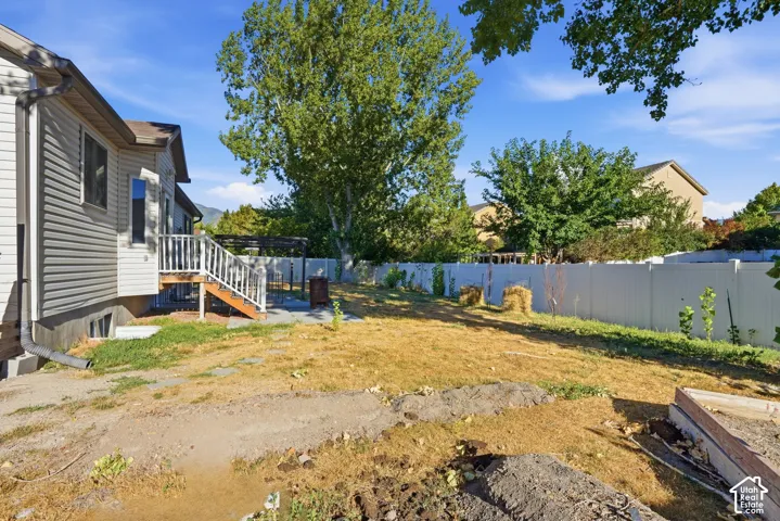 Siding exterior with a built-in deck featuring white railings, a concrete patio, and a privacy fence