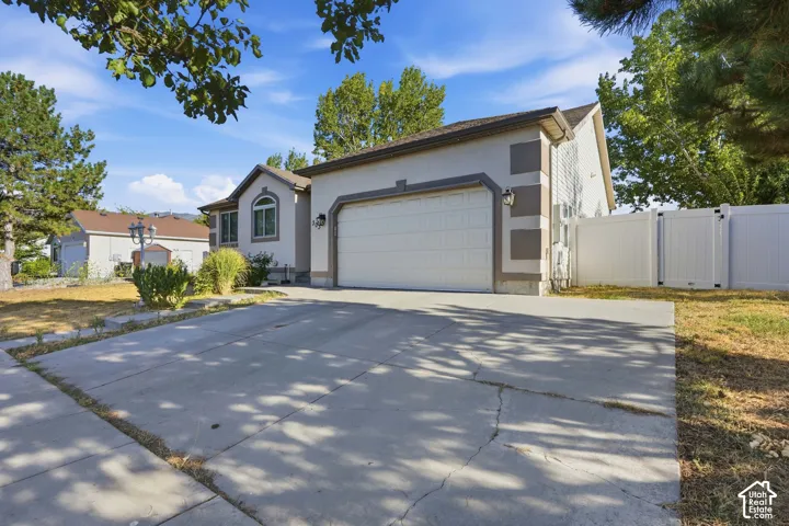 Exterior stucco finish with decorative trim, arched window, and attached garage