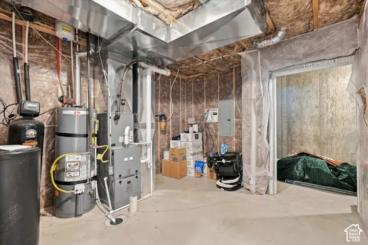 Basement utility area featuring a water heater, furnace, water softener, and exposed ductwork