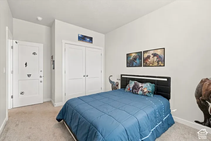 Plush carpet flooring, white painted walls, and a built-in closet with double doors