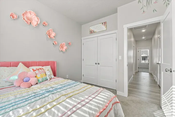Recessed lighting illuminates the hallway with wood-finish flooring