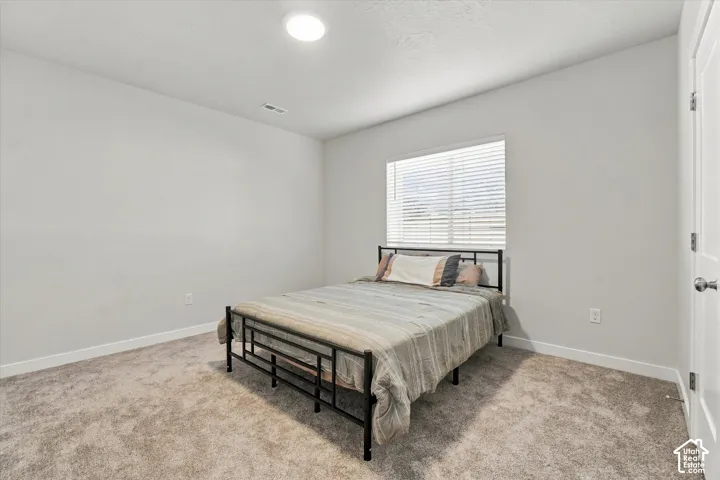 Neutral wall paint, recessed lighting, window with blinds, carpeted flooring, and white trim