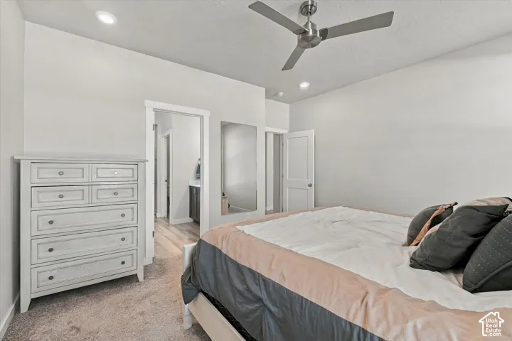 Recessed lighting, ceiling fan, white paneled door, and wood-finish flooring visible through doorway