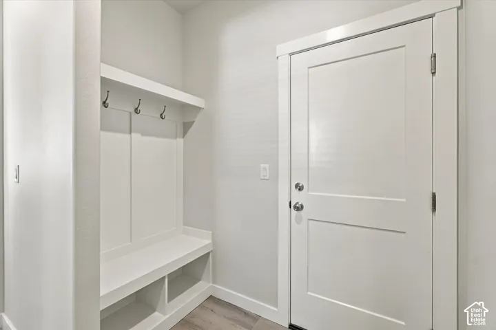 Built-in mudroom bench with storage cubbies, wall hooks, and an overhead shelf