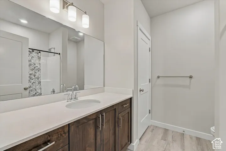 Dark wood-finish vanity with a light-toned countertop, undermount sink, and a chrome-finish faucet