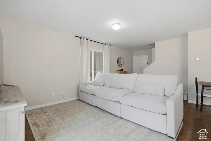 Wood-finish flooring throughout, natural light from a large window, recessed lighting, and a neutral color palette