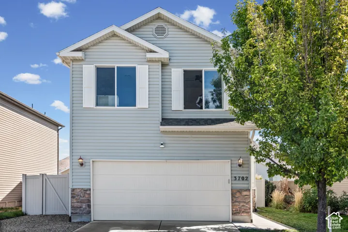 Light blue siding exterior with white window shutters and stone accents