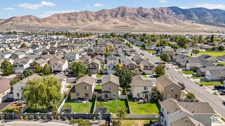 Residential neighborhood with consistent architectural styles, paved streets, and a mountainous backdrop