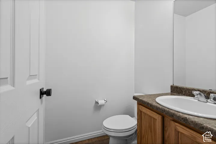 Wood-finish vanity with an integrated sink and chrome fixtures, complemented by a large wall-mounted mirror