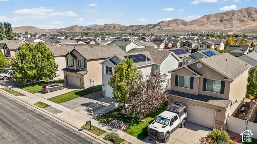 Two-story residence featuring a two-car garage, front yard landscaping, and a fenced backyard with a patio