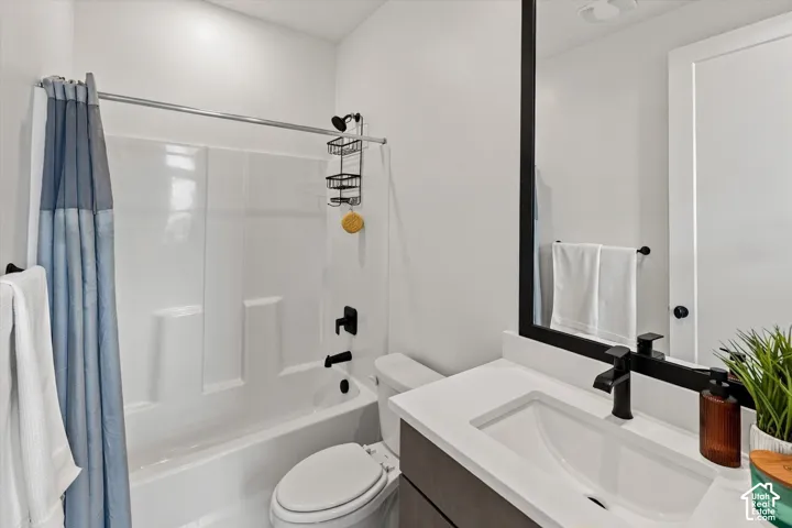 Modern bathroom with a white vanity featuring an integrated sink, matte black faucet, and a large framed mirror