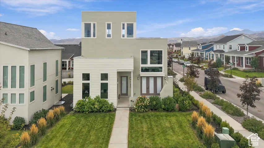 Modern architectural design featuring a clean-lined facade with mixed exterior materials including light-colored siding and stone accents