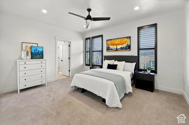 Recessed lighting, ceiling fan, and light-toned carpeting