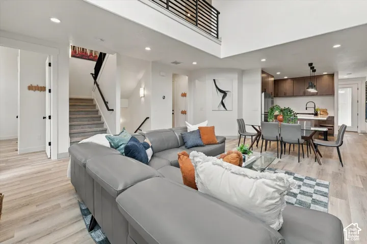 Two-story living area with high ceilings, wood-finish flooring, and recessed lighting