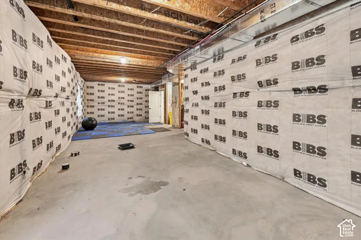 Unfinished basement featuring exposed wood joists and concrete flooring