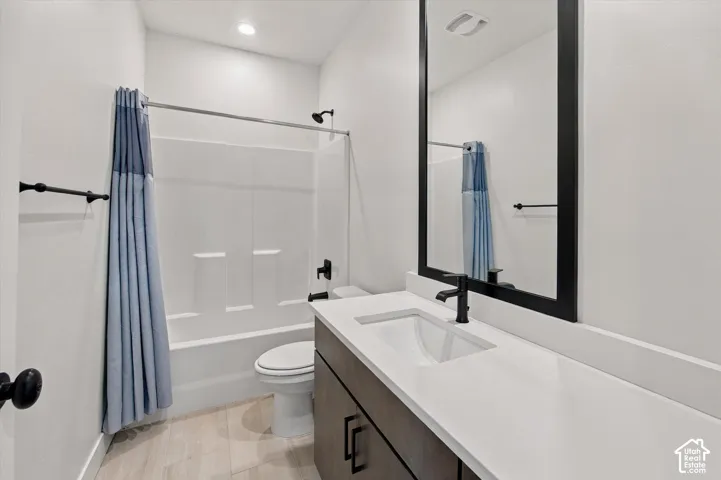 Bathroom featuring a single vanity with a white countertop, an undermount sink, a framed mirror, and matte black fixtures