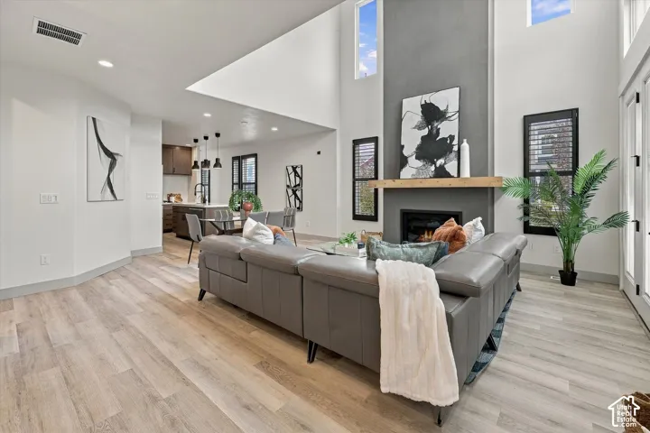 Vaulted ceilings, wood-finish flooring, and a fireplace with a wood mantle