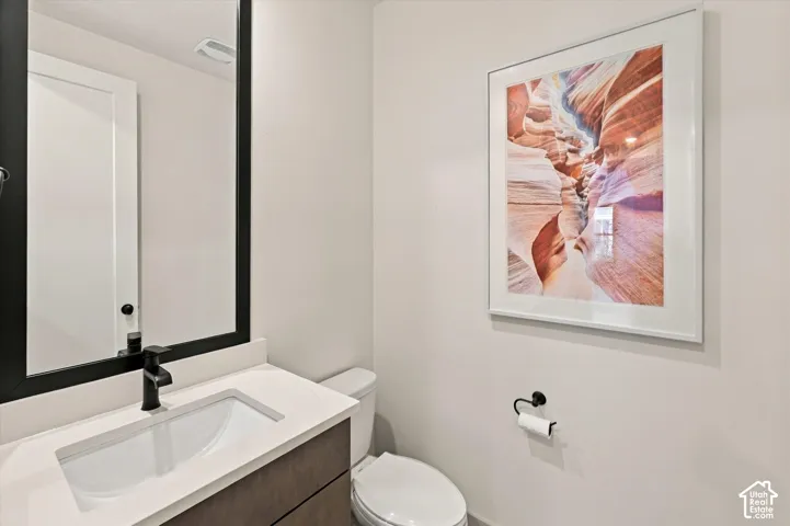 Modern vanity with a rectangular undermount sink, white countertop, and matte black faucet