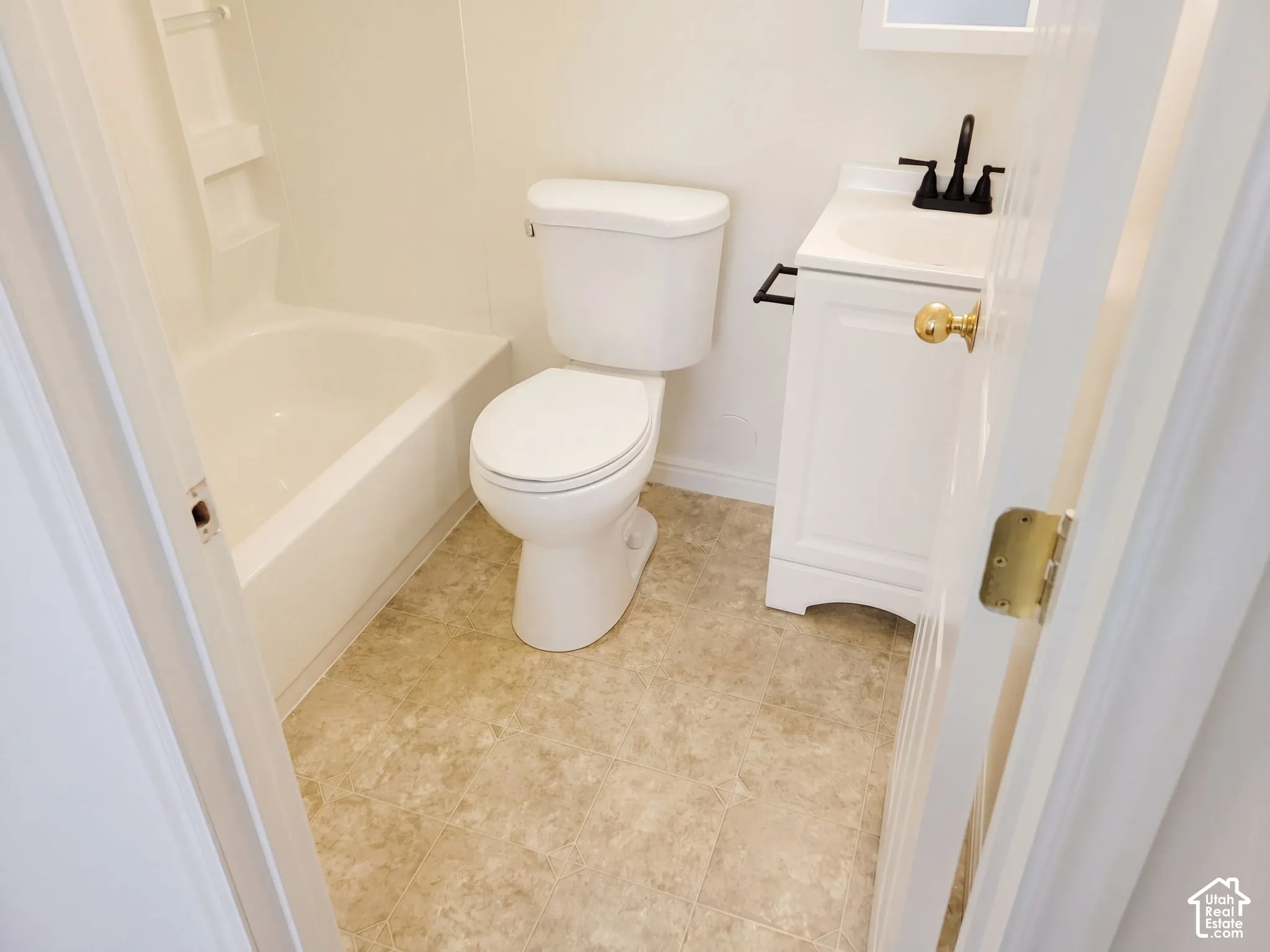 White bathtub and shower surround, toilet, and a white vanity with a rectangular sink