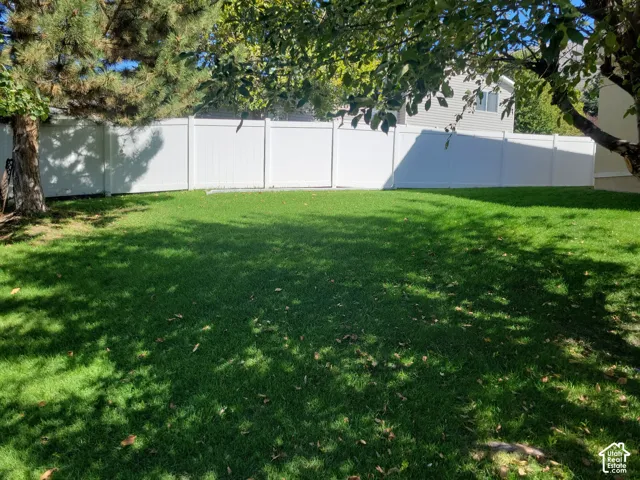 Expansive green lawn with a full privacy fence