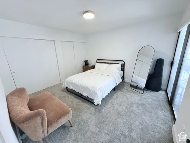 Wall-to-wall carpet flooring, double sliding closet doors, ceiling light fixture, and a sliding glass door