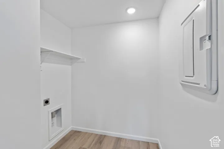 Dedicated laundry area with a white wire shelf, wood-finish flooring, and recessed lighting. HOME TO BE BUILT! Pictures are of another similar Spec and not of this exact home. Colors and other options may vary from those seen here. Please see Sales consul