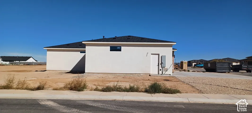 Crisp white stucco exterior with a dark shingle roof and a single window