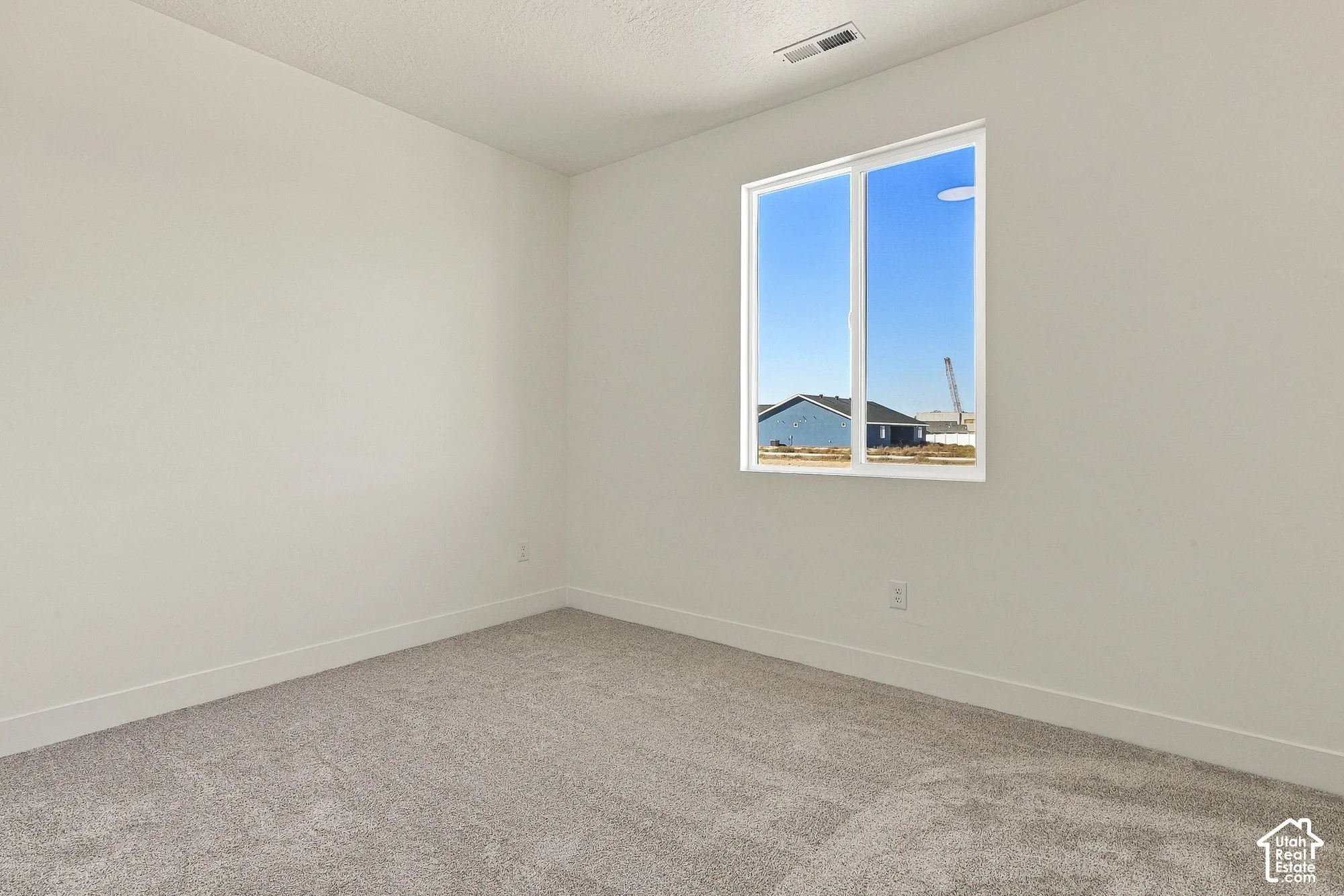 Room featuring neutral wall finishes, plush wall-to-wall carpeting, and a dual-pane sliding window
