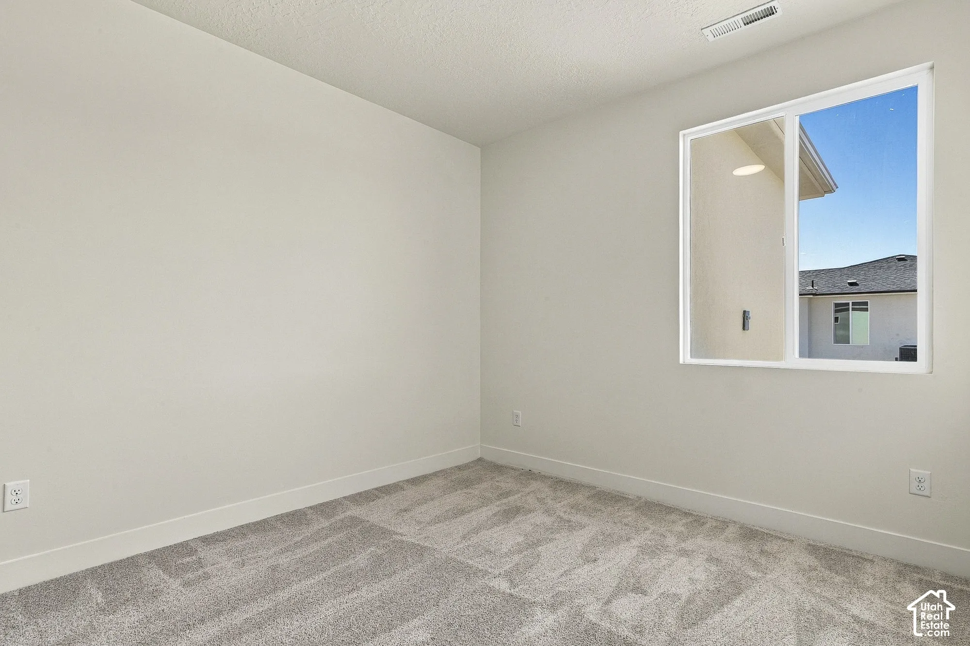 Neutral-toned interior featuring wall-to-wall carpeting and a single-pane sliding window