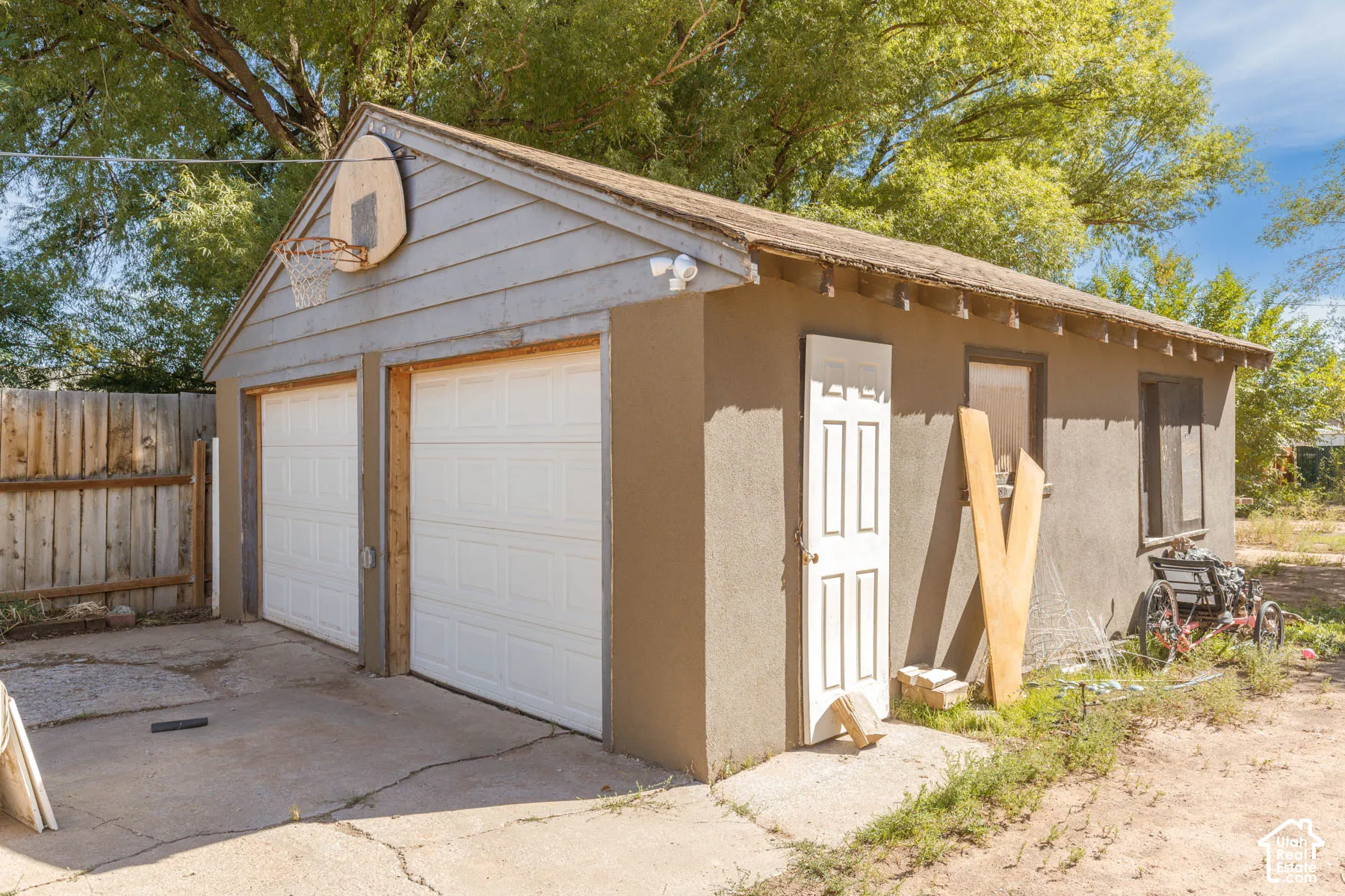 Detached two-car garage with white panel doors and a side entry door