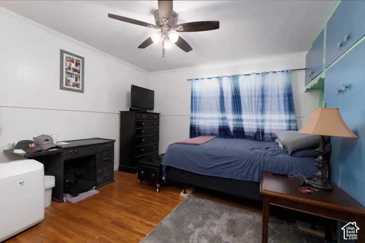 Hardwood flooring throughout, ceiling fan with integrated lighting, and built-in overhead cabinetry
