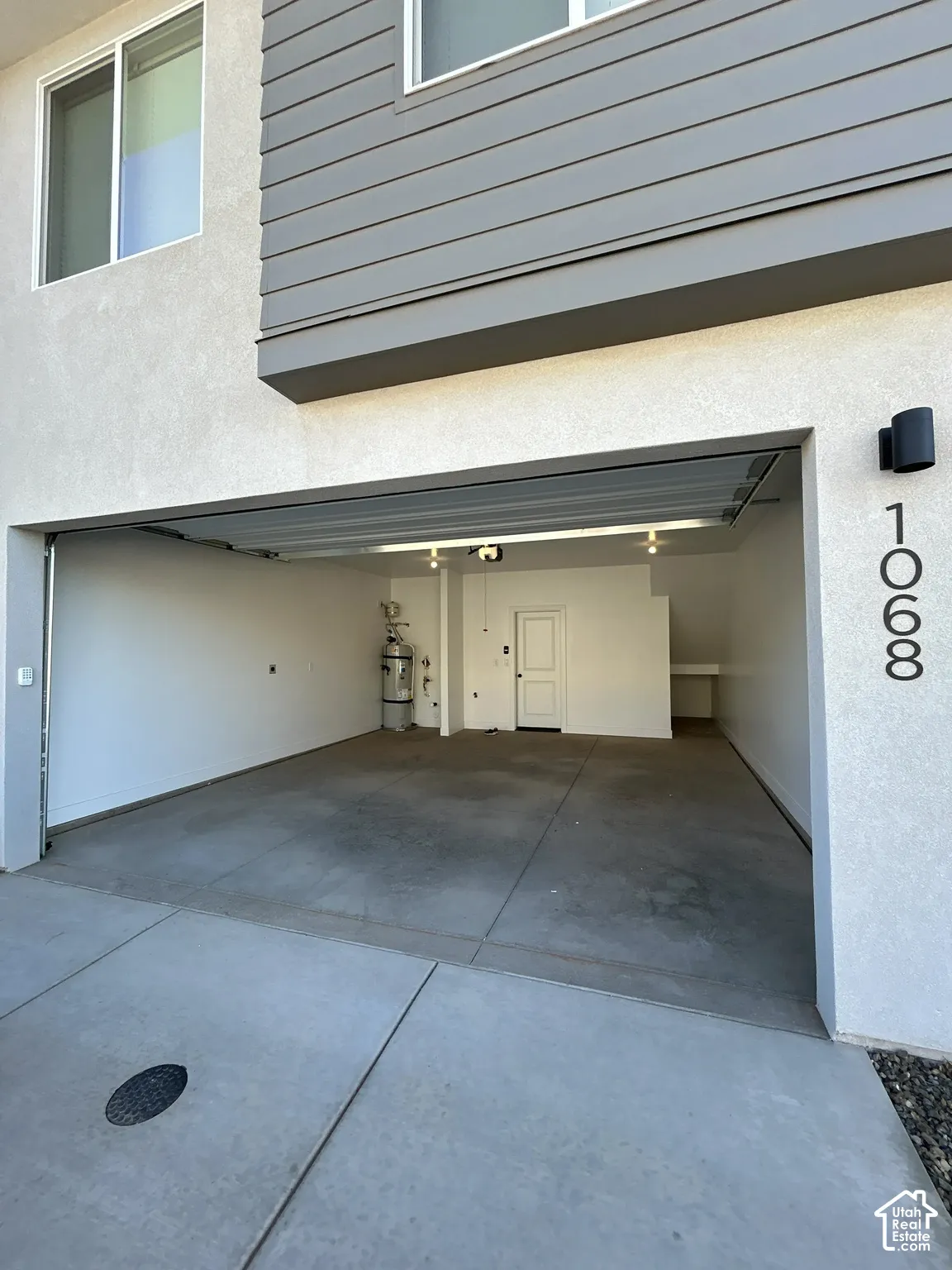 Two-car garage with concrete flooring, built-in shelving, and a water heater