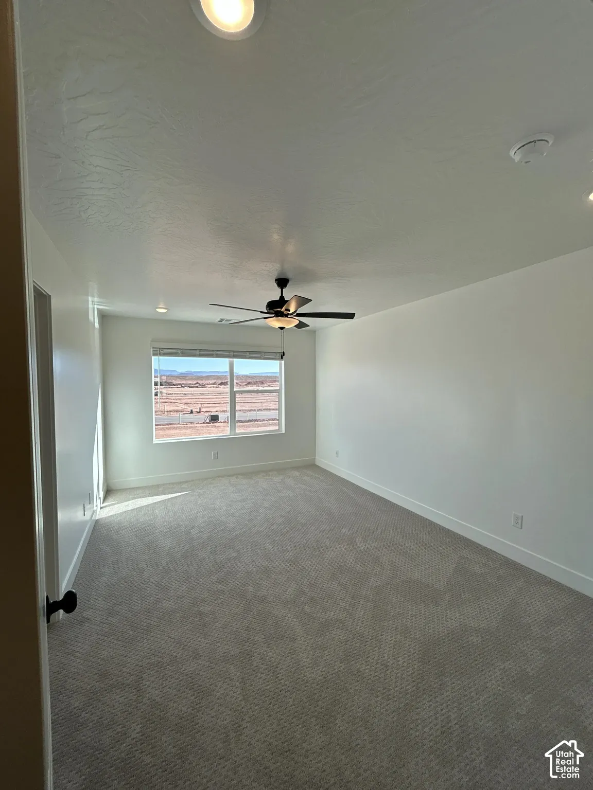 Expansive room featuring recessed lighting, a ceiling fan with light, a large window, and light-toned carpeting