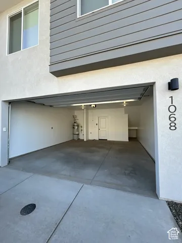 Two-car garage with concrete flooring, built-in shelving, and a water heater