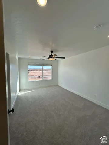 Expansive room featuring recessed lighting, a ceiling fan with light, a large window, and light-toned carpeting