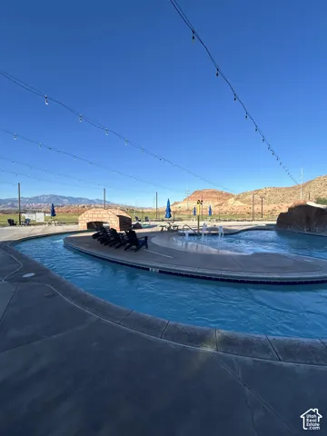 Expansive outdoor swimming area featuring a lazy river, water play features, and strung overhead lighting