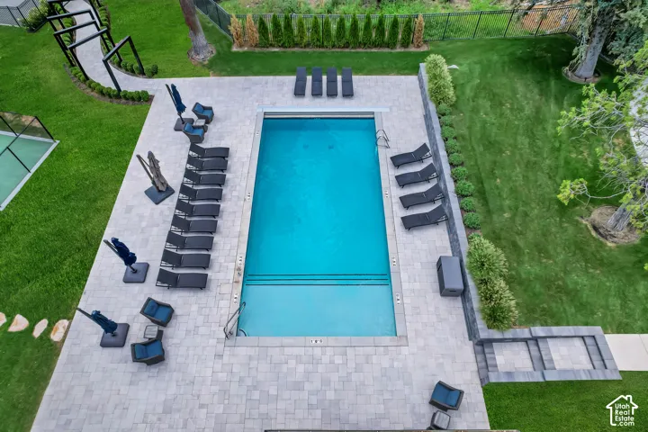 Resort-style pool with integrated steps, surrounded by extensive paver decking