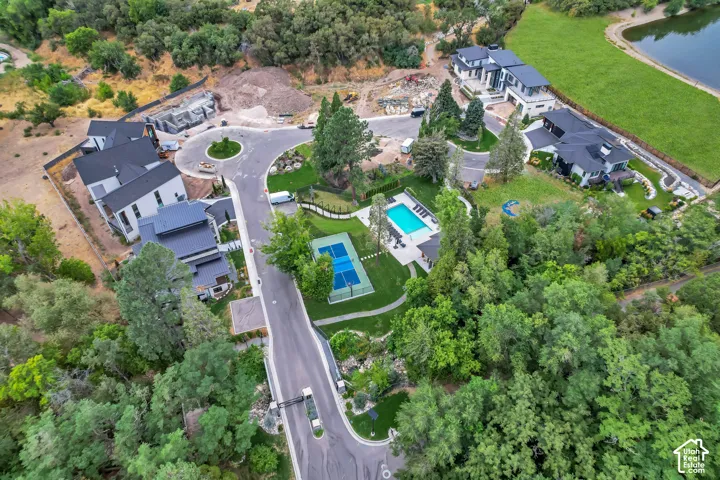 Cul-de-sac community with modern residences, private swimming pool, and tennis court surrounded by mature trees