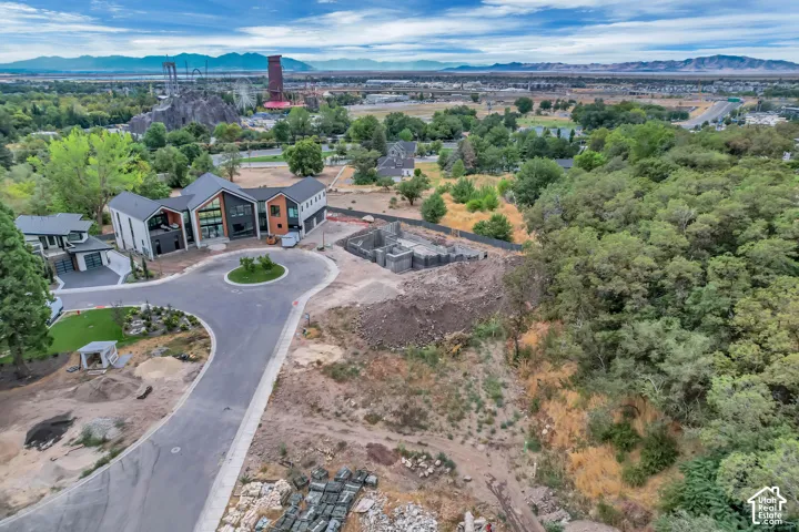 Modern architectural style with a multi-textured exterior, expansive glass panels, and a landscaped circular driveway