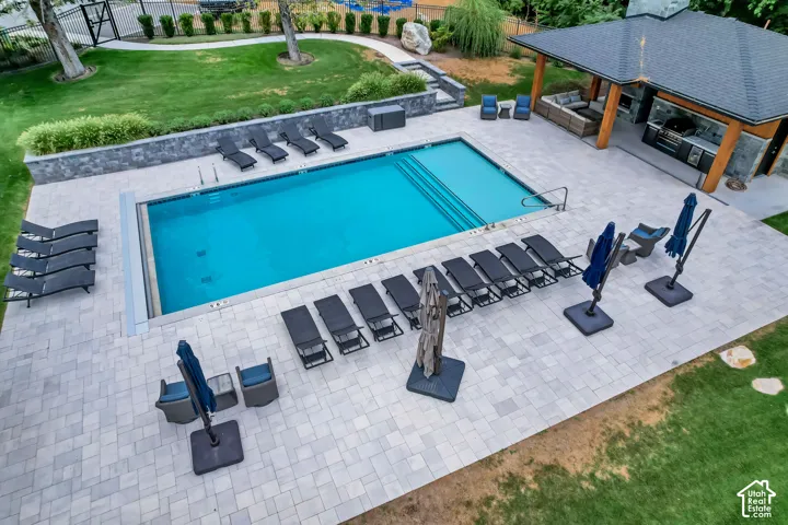 Rectangular swimming pool with integrated steps, surrounded by light-toned paver patio